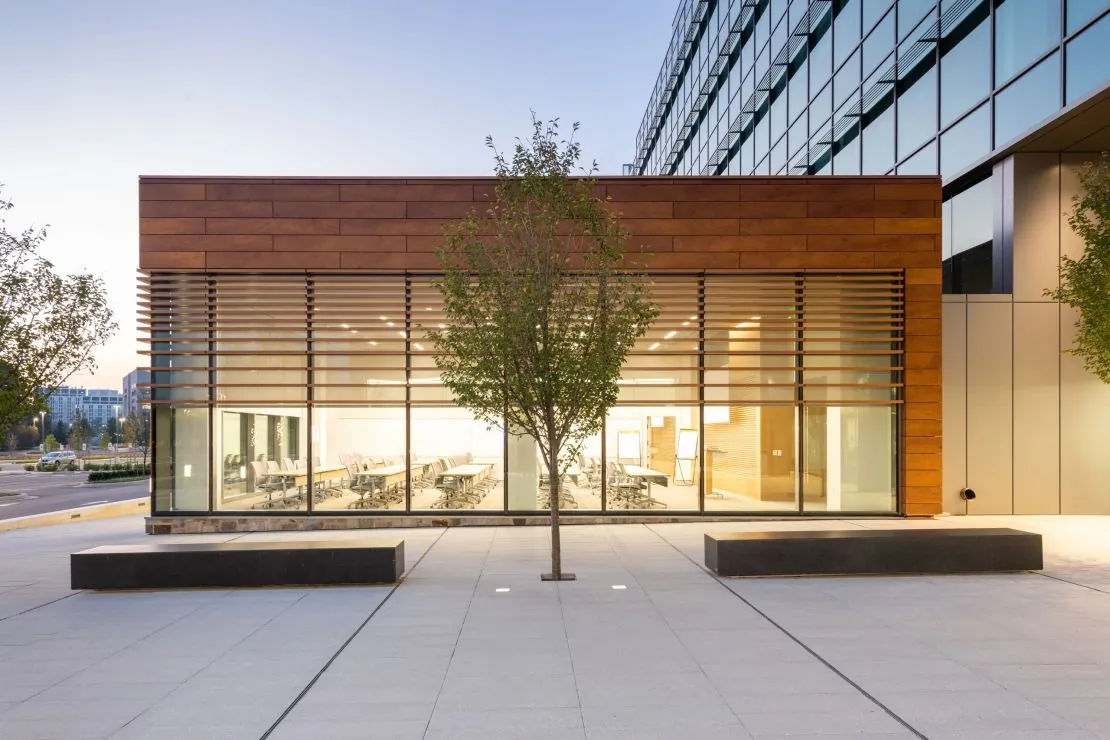 Wood-grain HPL rainscreen panels around a completed glazed building entrance