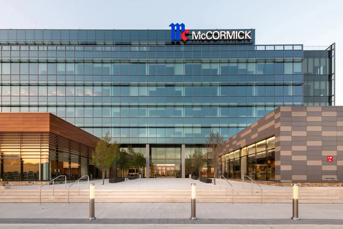 Terracotta rainscreen cladding at the base of a glass office tower — drained and back-ventilated exterior panel facade system