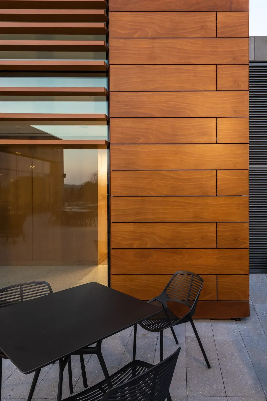 Terracotta rainscreen and timber screen detail on a completed exterior facade