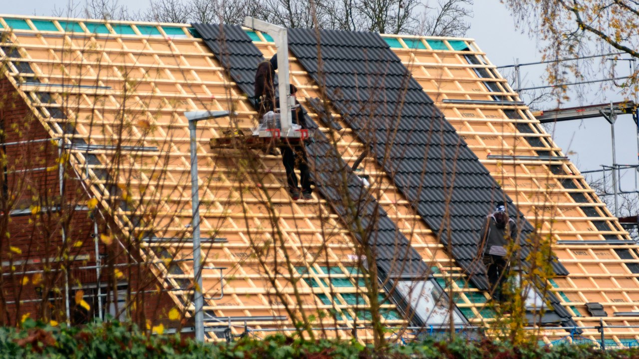 Continuous exterior insulation being installed behind a rainscreen cavity on a building wall for thermal performance